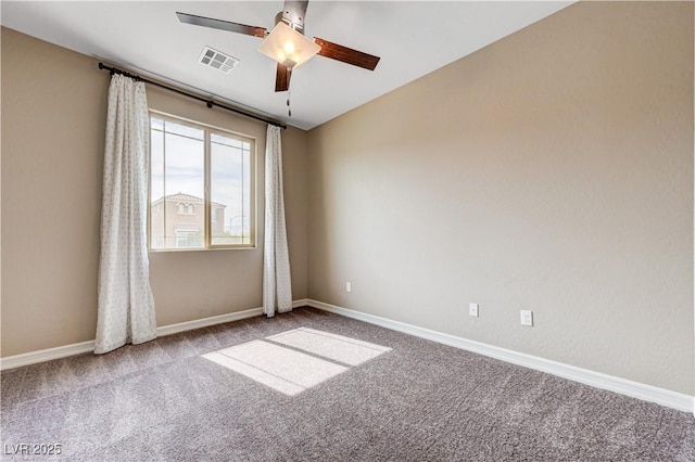 carpeted empty room featuring ceiling fan and baseboards