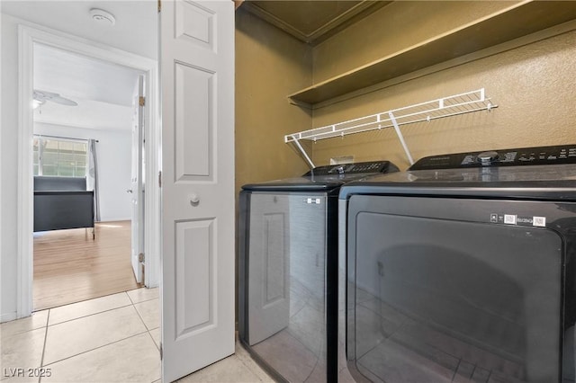 laundry area with washer and dryer, light tile patterned flooring, and ornamental molding