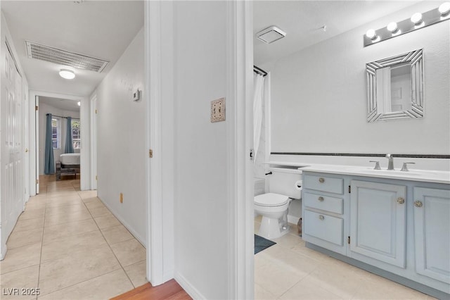 bathroom featuring tile patterned flooring, toilet, and vanity