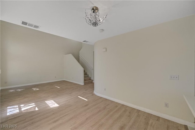 additional living space with light wood-style flooring, a chandelier, and baseboards