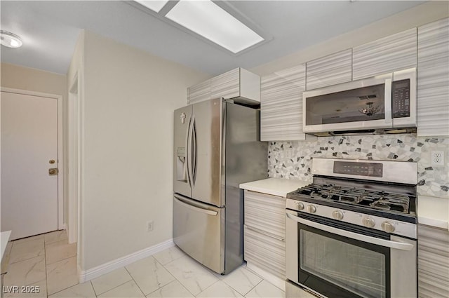 kitchen featuring appliances with stainless steel finishes, light marble finish floors, light countertops, and modern cabinets