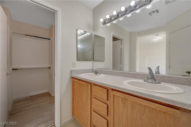 bathroom featuring double vanity and baseboards