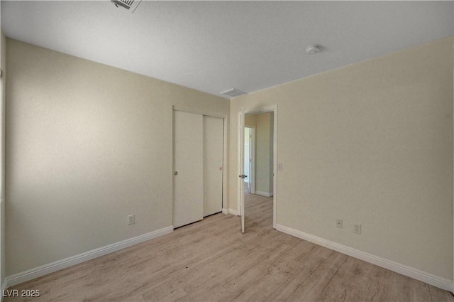 spare room featuring light wood-style flooring, baseboards, and a smoke detector