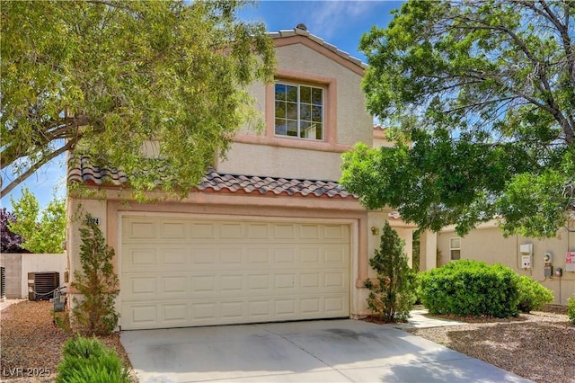 mediterranean / spanish-style house featuring driveway, stucco siding, a garage, a tiled roof, and central AC