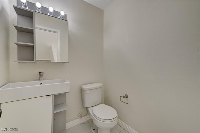 half bathroom with toilet, baseboards, and vanity
