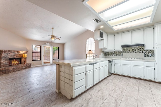 4378 Cherrystone Ct, Las Vegas, NV 89121 - kitchen with tile countertops, lofted ceiling, a peninsula, open floor plan, and backsplash