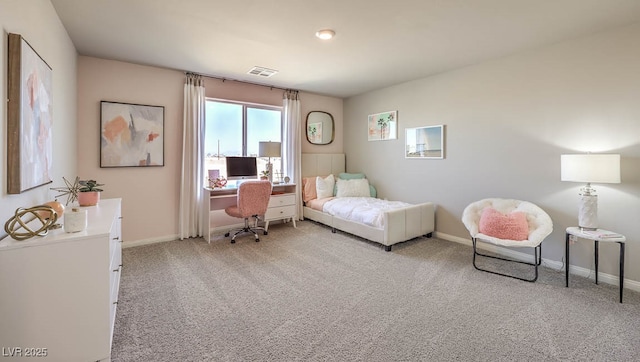 carpeted bedroom featuring baseboards and an office area