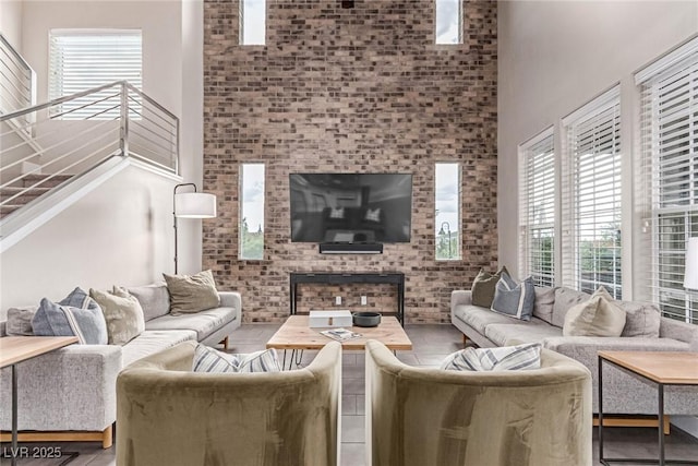 3165 Via Como Dr, Henderson, NV 89044 - living room featuring a high ceiling, brick wall, stairway, and a fireplace