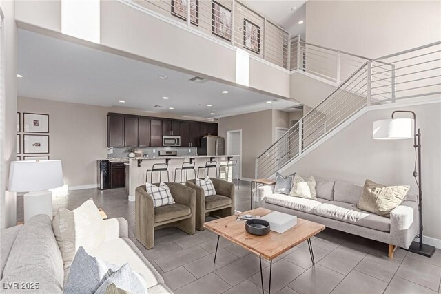 3165 Via Como Dr, Henderson, NV 89044 - living room featuring stairway, recessed lighting, light tile patterned flooring, a towering ceiling, and baseboards
