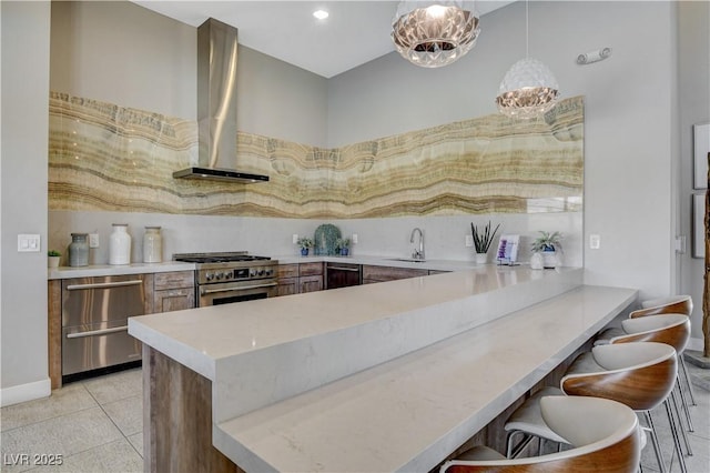 11280 Granite Ridge Dr Unit 1035, Las Vegas, NV 89135 - kitchen featuring stainless steel appliances, wall chimney exhaust hood, a peninsula, a sink, and a kitchen breakfast bar