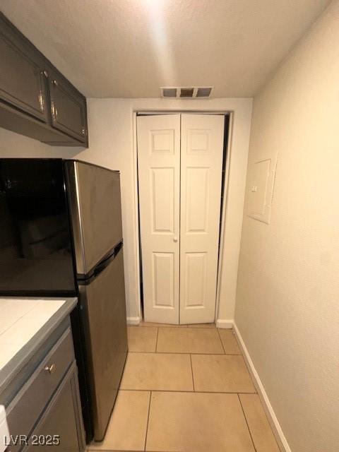 1830 N Pecos Rd Unit 155, Las Vegas, NV 89115 - kitchen featuring freestanding refrigerator, baseboards, light tile patterned floors, light countertops, and gray cabinets