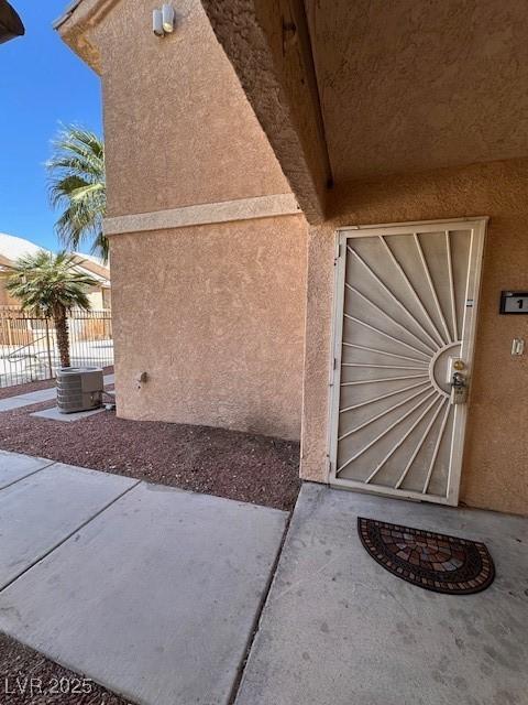 1830 N Pecos Rd Unit 155, Las Vegas, NV 89115 - doorway to property with stucco siding, cooling unit, and a patio area