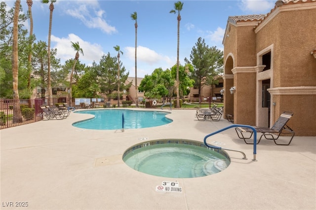 community pool with a hot tub, a patio, and fence