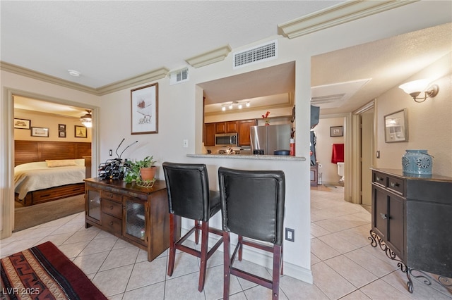 dining space with light tile patterned flooring, crown molding, and a textured ceiling