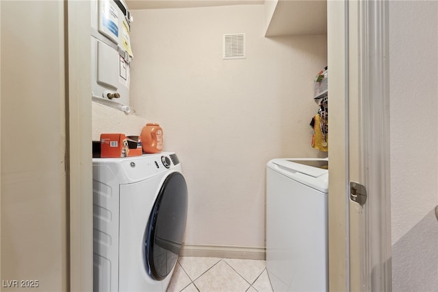 laundry area featuring washing machine and clothes dryer and light tile patterned floors