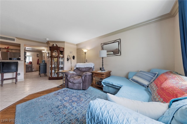 living room with ornamental molding and tile patterned flooring