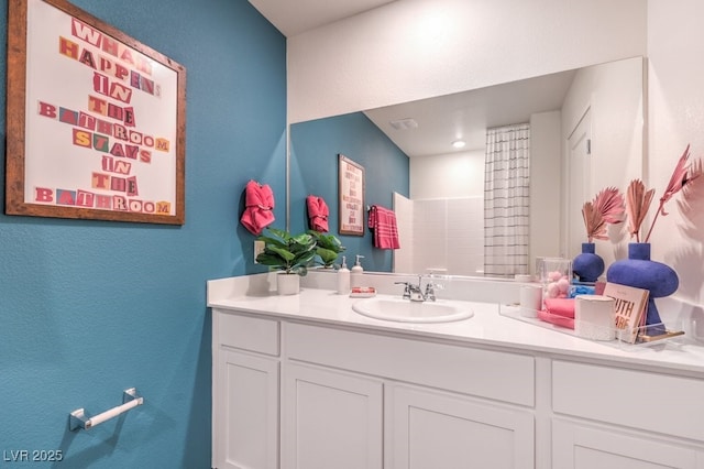 bathroom with a textured wall and vanity