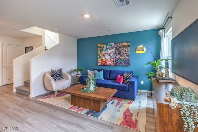 living area with stairs and wood finished floors