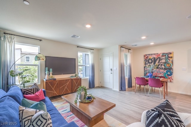 living room with light wood-type flooring, recessed lighting, and baseboards