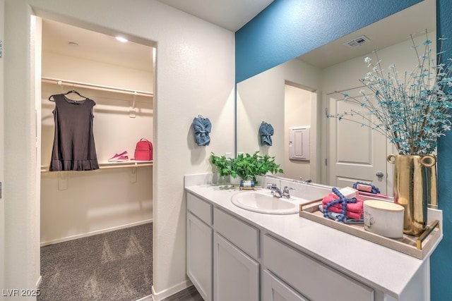 bathroom featuring vanity and a walk in closet