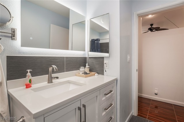 bathroom featuring a ceiling fan, baseboards, wood finished floors, and vanity