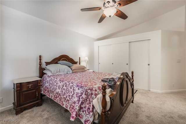 bedroom with light carpet, a closet, vaulted ceiling, a ceiling fan, and baseboards