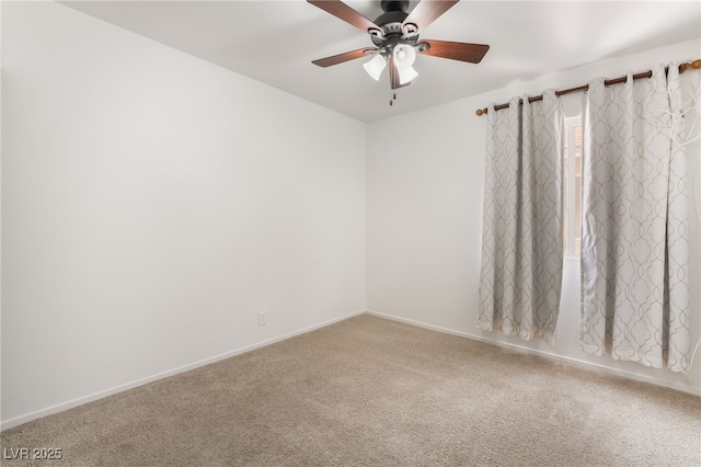 carpeted empty room with a ceiling fan and baseboards