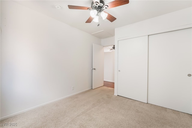 unfurnished bedroom featuring light colored carpet, a closet, and a ceiling fan