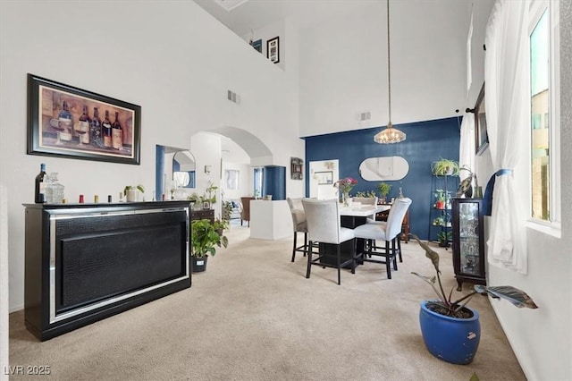 3389 Commendation Dr, Las Vegas, NV 89117 - carpeted dining space with arched walkways, a high ceiling, and baseboards