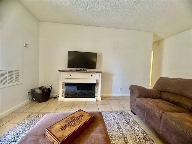 3151 Soaring Gulls Dr Unit 1023, Las Vegas, NV 89128 - living room with tile patterned floors, a textured ceiling, a glass covered fireplace, and baseboards