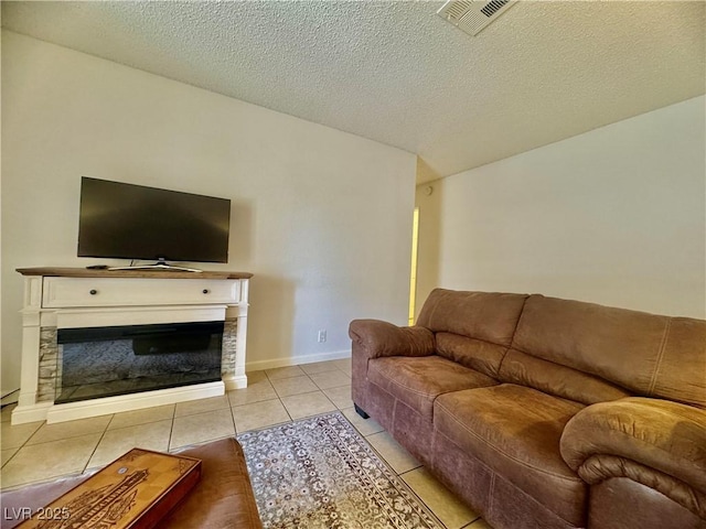 3151 Soaring Gulls Dr Unit 1023, Las Vegas, NV 89128 - living room with light tile patterned floors, a glass covered fireplace, and a textured ceiling