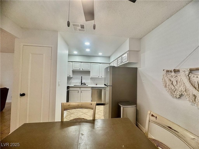 3151 Soaring Gulls Dr Unit 1023, Las Vegas, NV 89128 - kitchen with stainless steel appliances, a sink, light tile patterned floors, baseboards, and a textured ceiling