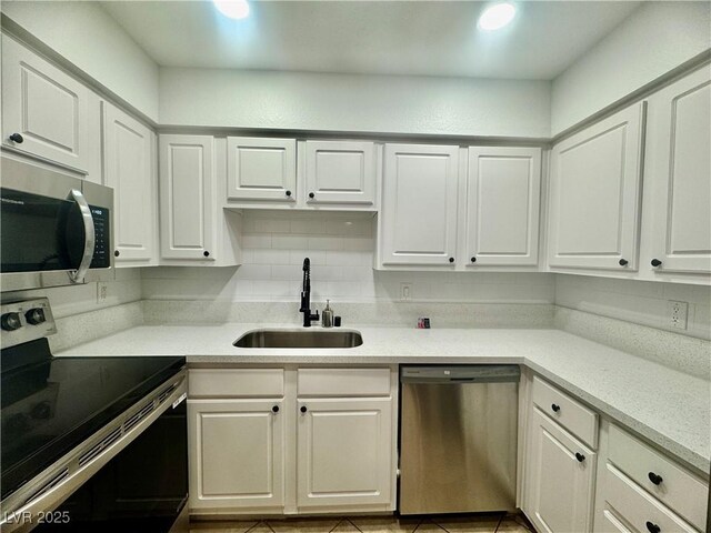 3151 Soaring Gulls Dr Unit 1023, Las Vegas, NV 89128 - kitchen featuring stainless steel appliances, a sink, white cabinets, and tasteful backsplash