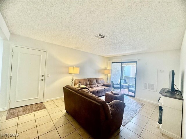 3151 Soaring Gulls Dr Unit 1023, Las Vegas, NV 89128 - living room with light tile patterned flooring, a textured ceiling, and baseboards