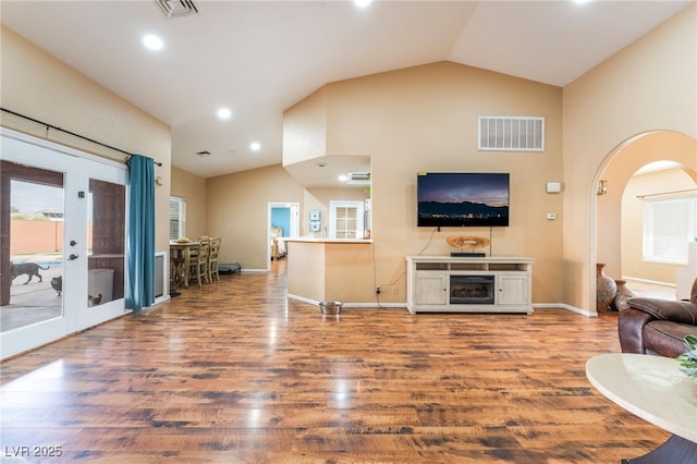 120 N Phyllis St, Las Vegas, NV 89110 - living room with lofted ceiling, arched walkways, french doors, wood finished floors, and recessed lighting