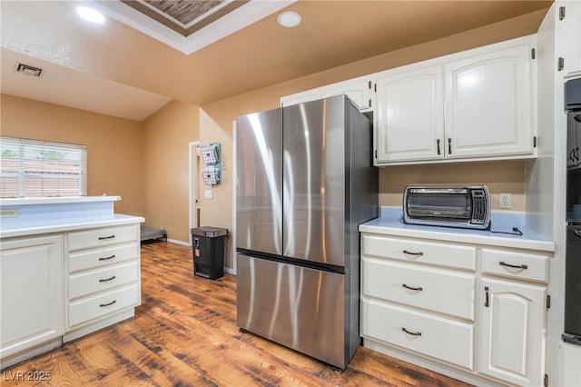 120 N Phyllis St, Las Vegas, NV 89110 - kitchen with freestanding refrigerator, light countertops, wood finished floors, white cabinetry, and recessed lighting