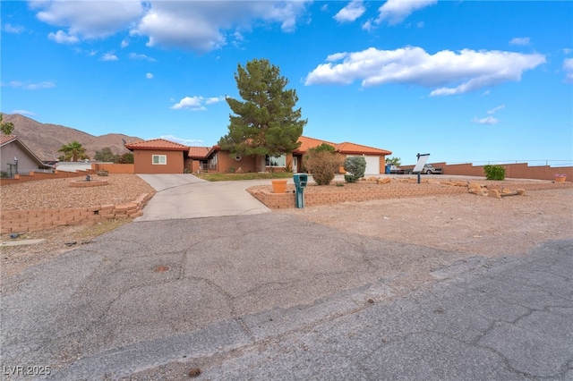120 N Phyllis St, Las Vegas, NV 89110 - view of front of house featuring concrete driveway, a tile roof, a mountain view, and stucco siding