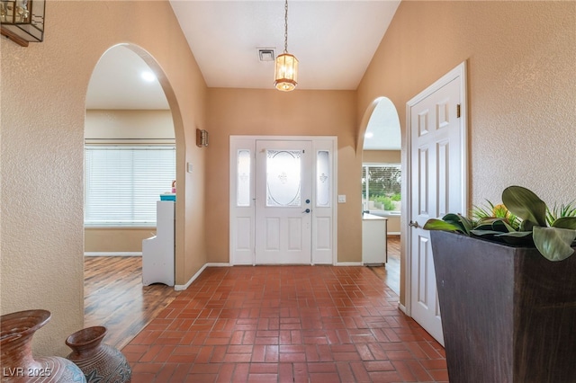 120 N Phyllis St, Las Vegas, NV 89110 - entrance foyer featuring arched walkways, brick floors, baseboards, and a textured wall