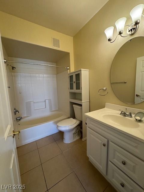 bathroom featuring tile patterned flooring, toilet, vanity, and washtub / shower combination