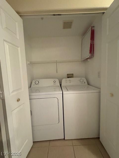 laundry room featuring washer and dryer and light tile patterned floors