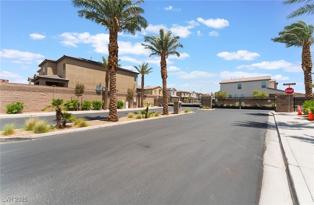 2767 Lindsey Springs St, Las Vegas, NV 89142 - view of asphalt street featuring traffic signs, a residential view, curbs, and a gated entry
