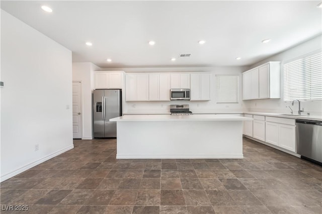 2767 Lindsey Springs St, Las Vegas, NV 89142 - kitchen featuring appliances with stainless steel finishes, a center island, white cabinets, light countertops, and recessed lighting