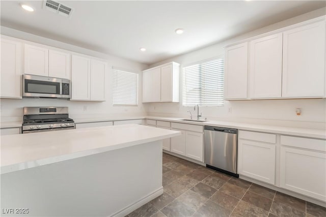 2767 Lindsey Springs St, Las Vegas, NV 89142 - kitchen with stainless steel appliances, white cabinetry, recessed lighting, light countertops, and dark stone finish flooring