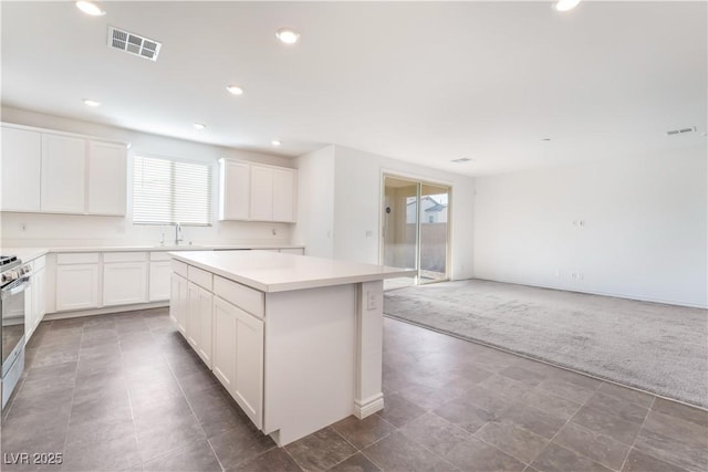 2767 Lindsey Springs St, Las Vegas, NV 89142 - kitchen with a kitchen island, carpet flooring, recessed lighting, white cabinetry, and light countertops