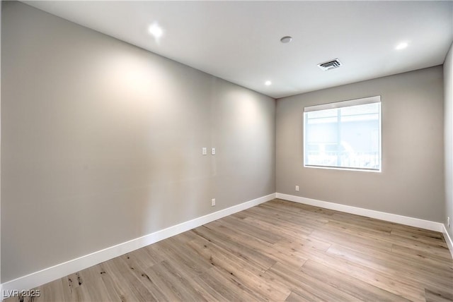 spare room featuring baseboards, light wood-type flooring, and recessed lighting