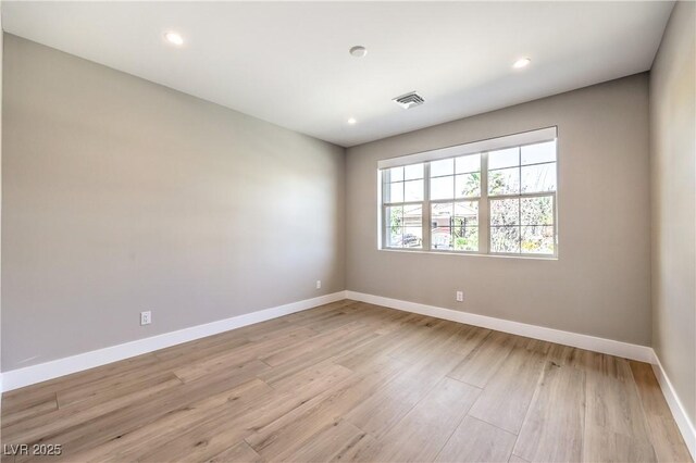 spare room with light wood finished floors, baseboards, and recessed lighting