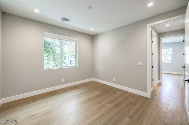 empty room featuring light wood finished floors, baseboards, and recessed lighting