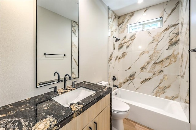 bathroom with toilet, wood finished floors, shower / bath combination, and vanity