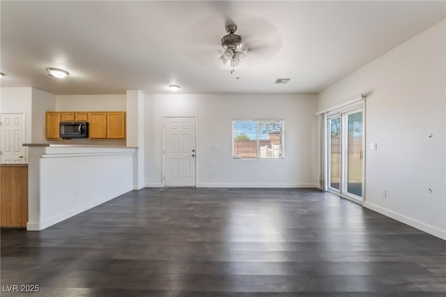 unfurnished living room featuring a ceiling fan, dark wood-style floors, and baseboards