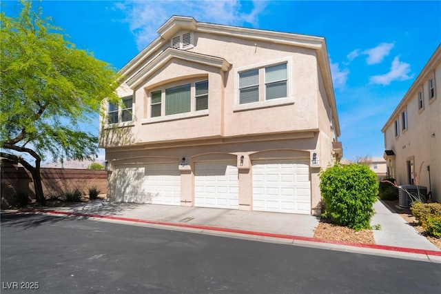 townhome / multi-family property featuring an attached garage, stucco siding, central air condition unit, and driveway